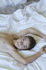 Boy reclining on bed  portrait