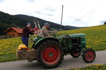 Alter Traktor faehrt im Schwarzwald