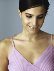 Woman in tank top smiling  looking down  portrait