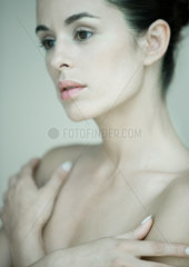 Woman with bare shoulders  arms folded across chest  portrait