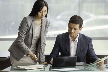 Assistant helping manager in office