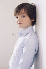Boy leaning against wall  portrait