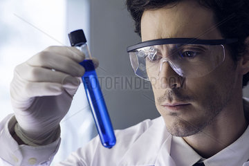 Scientist examining test tube in lab