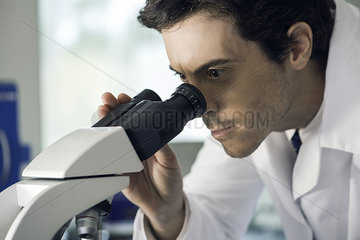 Doctor analyzing lab results under microscope