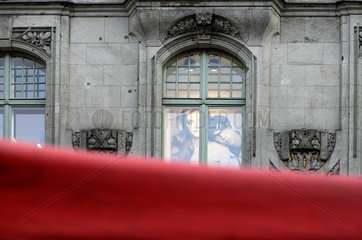 Berlin  Plakat von H&M hinter einem Fenster