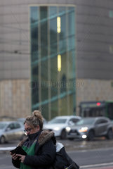 Polen  Poznan - Frau beschaeftigt mit ihrem smartfone im winterlichen Stadtzentrum