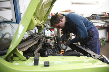 Deutschland  ein Kfz-Mechaniker arbeitet in der Werkstatt an einem Auto