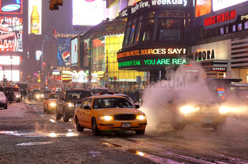 New York City  USA  Yellow Cabs fahren am Times Square ueber rauchende Gullis