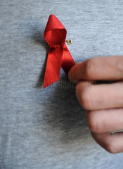 Berlin  Deutschland  Rote Schleife an der Brust eines AIDS-kranken