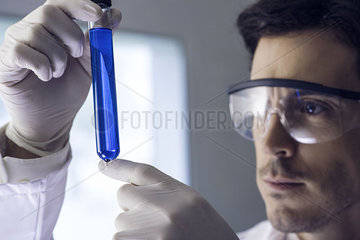 Scientist examining test tube