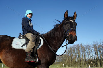 Neu Kaetwin  Deutschland  Junge sitzt ohne Helm auf einem Pferd