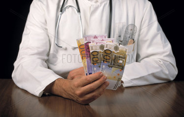 Arzt mit Stethoskop und Eurogeldscheinen in einer Hand