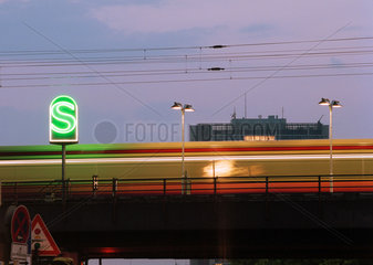 Ein S-Bahn Zug in der Daemmerung mit dem gruen leuchtenden Logo der S-Bahn