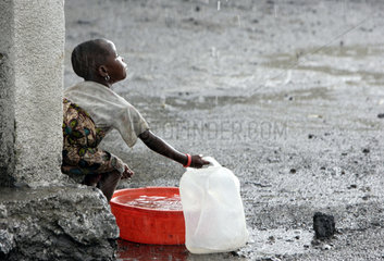 Goma  Demokratische Republik Kongo  Kind faengt Regenwasser auf