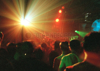 Besucher eines Clubs in farbigem Scheinwerferlicht