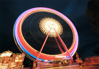 Ein beleuchtetes Riesenrad bei Nacht in Bewegung