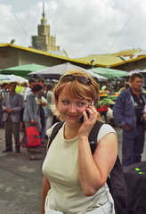 Junge Frau mit Handy am Zentralmarkt in Riga  Lettland