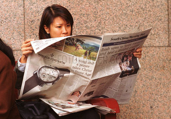 Angestellte der Boerse bei der Mittagspause beim Zeitunglesen  Hongkong