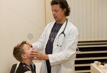 Duisburg  Deutschland  ein Arzt untersucht einen kleinen Jungen in seiner Praxis