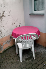 Sangerhausen  Deutschland  leerer Tisch und Stuhl in der Ecke eines maroden Innenhofs einer Pension