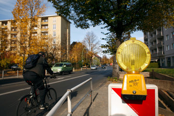 Berlin  Deutschland  ein Fahrradfahrer faehrt an einer Baustellenbegrenzung vorbei