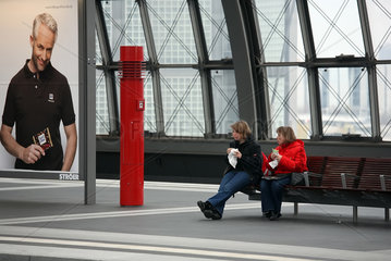Berlin  Deutschland  Mutter und Tochter essen einen Snack am Bahnsteig