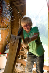 Blatti Alm  Schweiz  ein Junge beim Holzhacken