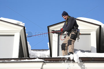 Berlin  Deutschland  Fassadenkletterer entfernt Schneebrocken vom Dach
