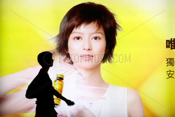 Hongkong  China  Silhouette einer Frauen vor einem Werbeplakat