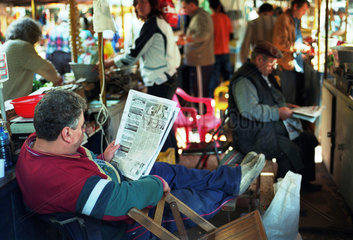 Verkaeufer liest Zeitung auf einem Obst- und Gemuesemarkt in Plovdiv  Bulgarien