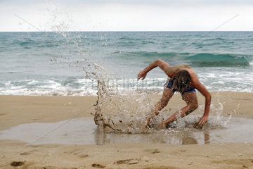 Noto  Italien  Junge stuerzt am Strand von Calamosche in eine Pfuetze