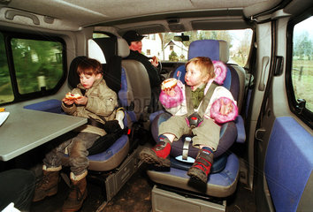 Geschwister auf Kindersitzen im Auto bei einem Familienausflug  Norddeutschland