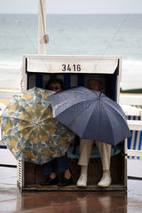 Westerland  Deutschland  Menschen mit Regenschirm im Strandkorb