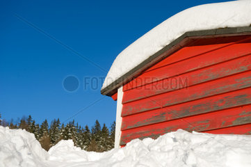 Schierke  Deutschland  eine eingeschneite  rot angestrichene Holzhuette