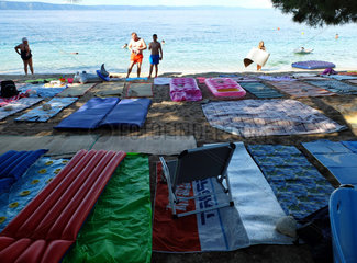 Zivogosce  Kroatien  mit Badetuechern belegter Strand an der Makarska Riviera