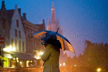 Bruegge  Belgien  eine Touristin fotografiert unter einem Regenschirm