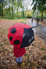 Berlin  Deutschland  Kind im Park mit einem Regenschirm