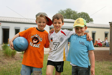 Saarbruecken  Deutschland  drei Jungen mit Ball im Garten einer Kindertagesstaette