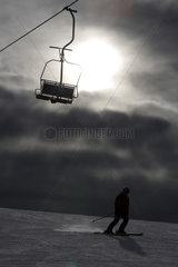 Innichen  Italien  Sessellift im Gegenlicht und Skifahrer auf der Piste