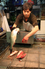 Hong Kong  China  Mann filetiert einen Fisch