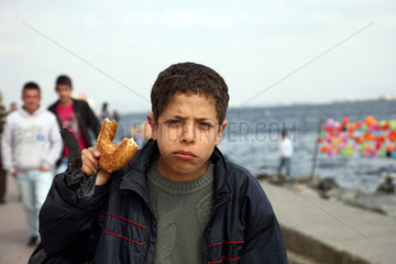 Istanbul  Tuerkei  ein Junge verspeist einen Sesamring