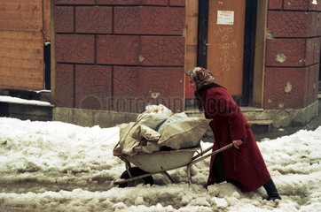 Sarajevo  Bosnien und Herzegowina  Frau schiebt eine Schubkarre durch den Schnee