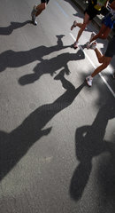 Berlin  Deutschland  Laeufer beim Marathon werfen ihre Schatten auf die Strasse
