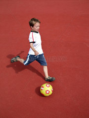 Berlin  Deutschland  kleiner Junge auf einem Fussballplatz