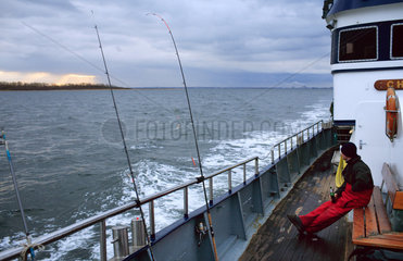 Wismar  Angler sitzt auf seinem Boot
