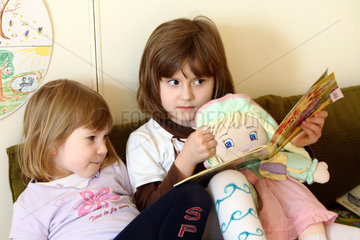 Berlin  Maedchen lesen in einem Kinderbuch