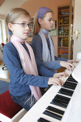 Hamburg  Deutschland  zwei junge Schwestern spielen zusammen Klavier