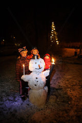 Belloe  Schweden  Nachtaufnahme  Kinder stehen hinter einem Schneemann