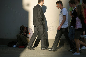 Posen  Polen  Passanten laufen an einem obdachlosen Mann vorbei