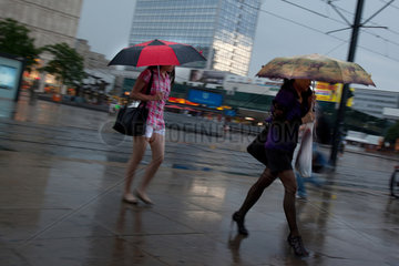Berlin  Deutschland  Passanten im Regen auf dem Alexanderplatz
